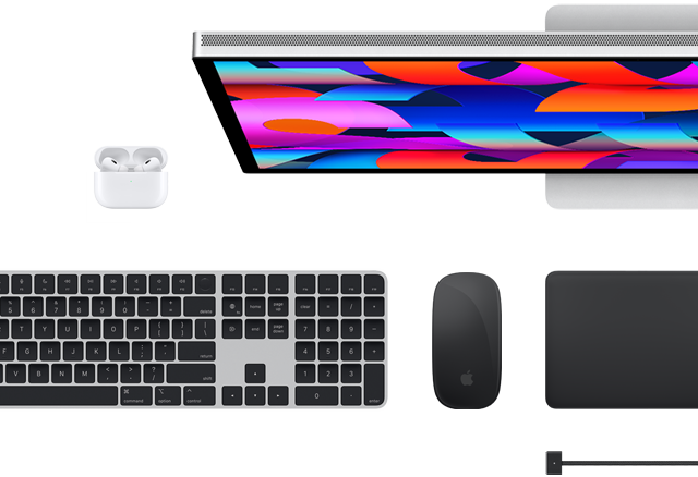 Accessoires Mac vus d’en haut : Studio Display, Magic Keyboard, Magic Mouse, Magic Trackpad, AirPods et câble de charge MagSafe